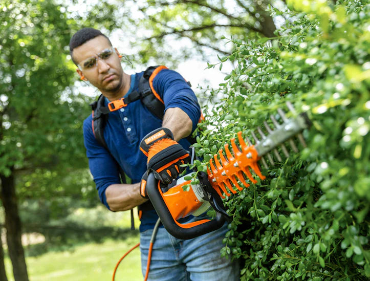 STIHL hedge trimmers for sale featuring an orange and white electric hedge trimmer with long cutting blades
