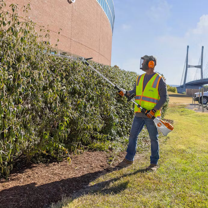 STIHL pole hedge trimmer with long adjustable shaft and orange white design for trimming high hedges