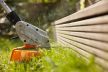 STIHL FSA45 trimmer for sale cutting grass near wooden fence in outdoor garden